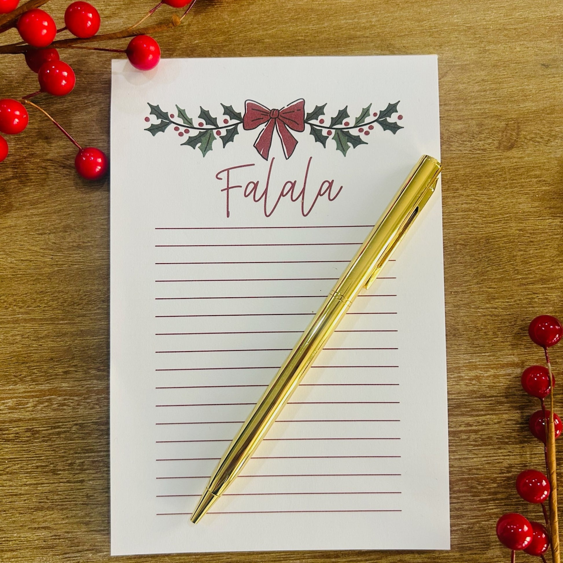 Christmas notepad and gold pen pop-by gift displayed with holiday greenery