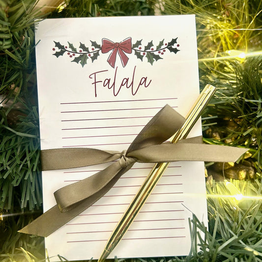 Christmas notepad and gold pen pop-by gift displayed with holiday greenery