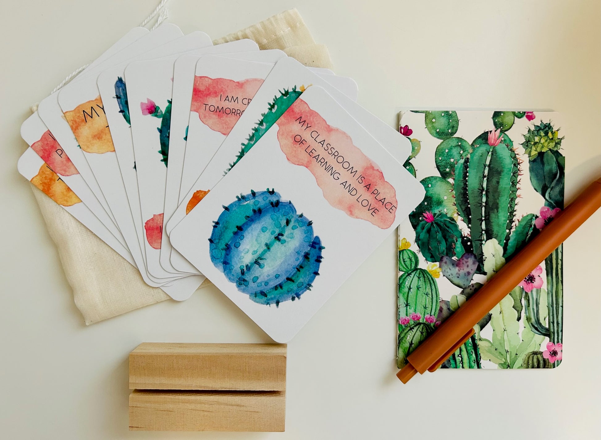Flat lay teacher appreciation cards with a cactus theme. includes notebook and pen